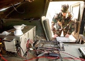 Army Staff Sgt. Dale Shoenfelt uses a laptop computer from the back of a Humvee to communicate via a secure Internet connection, in a demonstration of a proposed new data transmission system. Ed Souza, Santa Maria Times, July 2004.